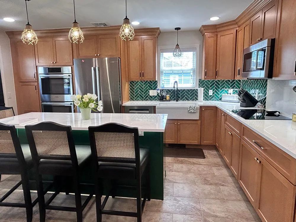 Kitchen with wood cabinets, green island, and stainless steel appliances.