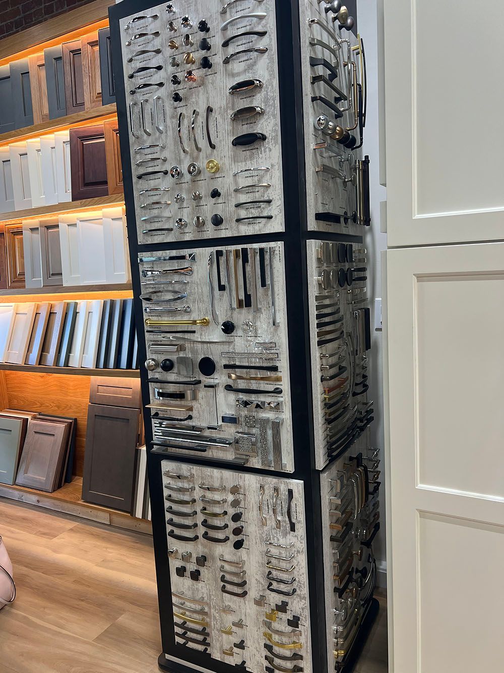 Tall display of black-and-white patterned textiles in a store, with shelves of books or samples beside it.
