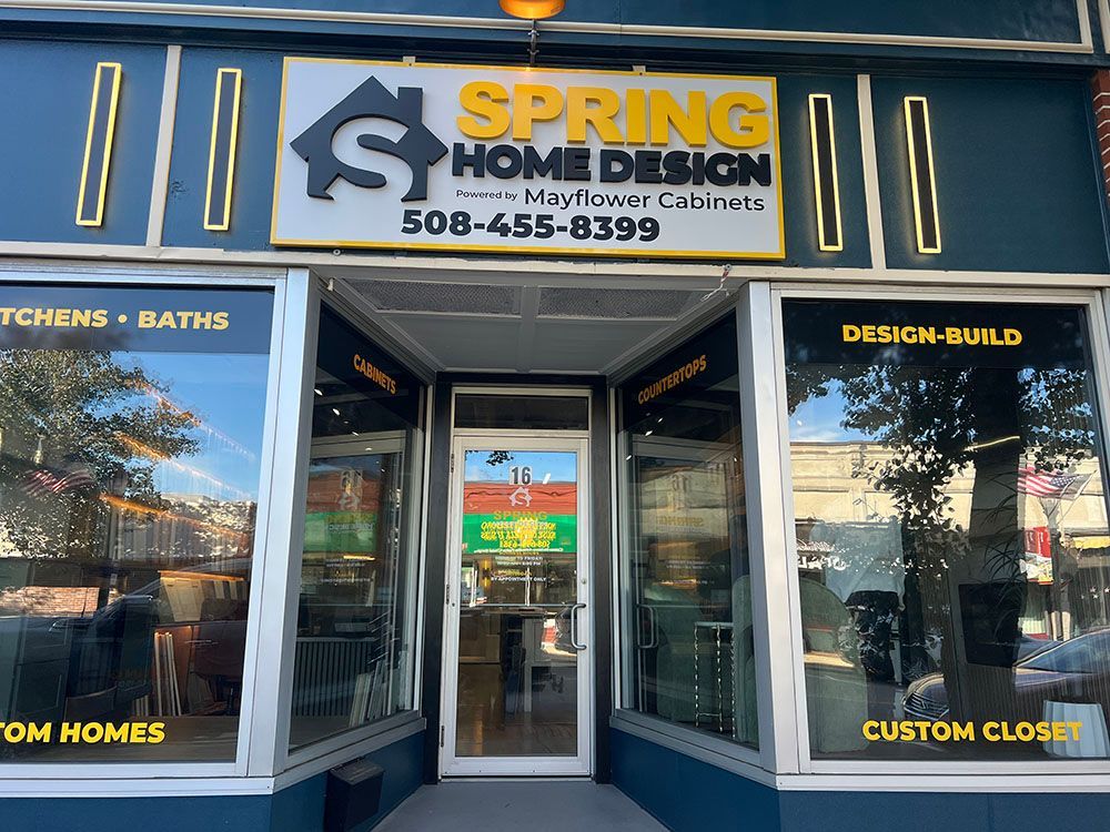 Storefront for Spring Home Design with black facade, gold lettering, and open glass doors