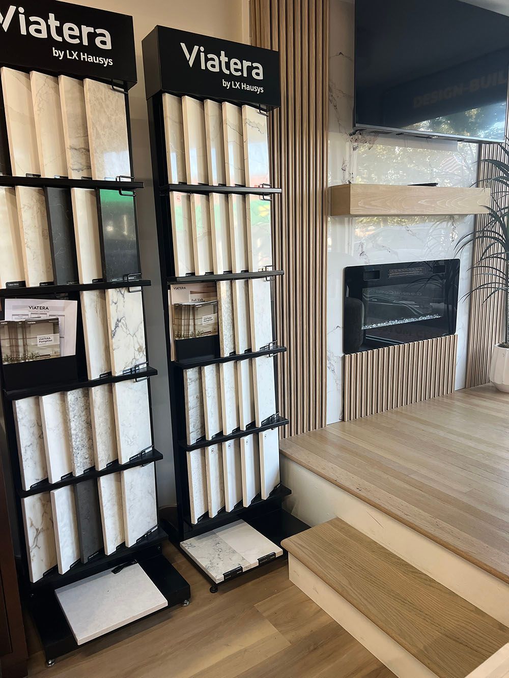 Display of Viatera stone samples beside a wood-and-stone showroom fireplace and steps