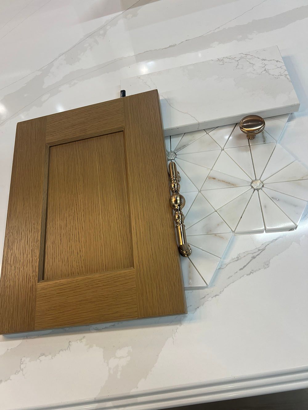 Open wooden jewelry box with gold clasp beside a clear geometric dish on a white surface