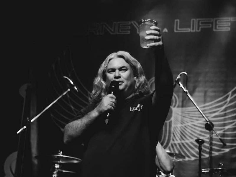 A man in a black shirt with the word love on it