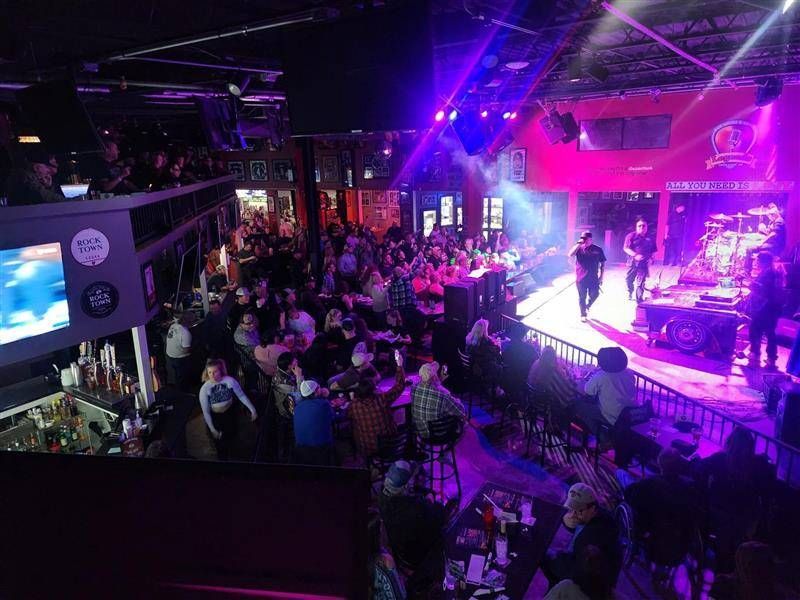 A crowd of people are gathered in a large room at a concert.