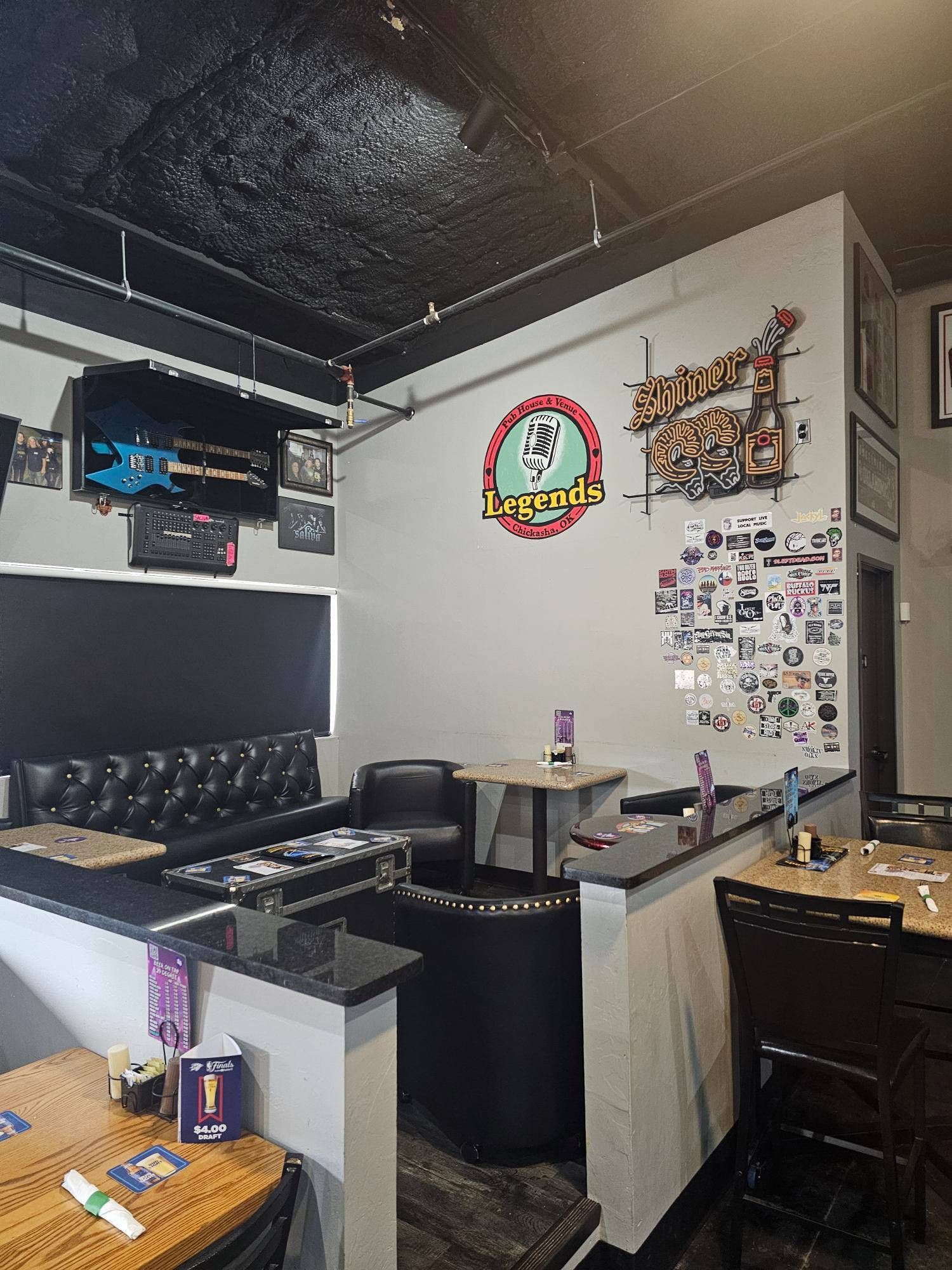 A restaurant with tables and chairs and a sign on the wall.