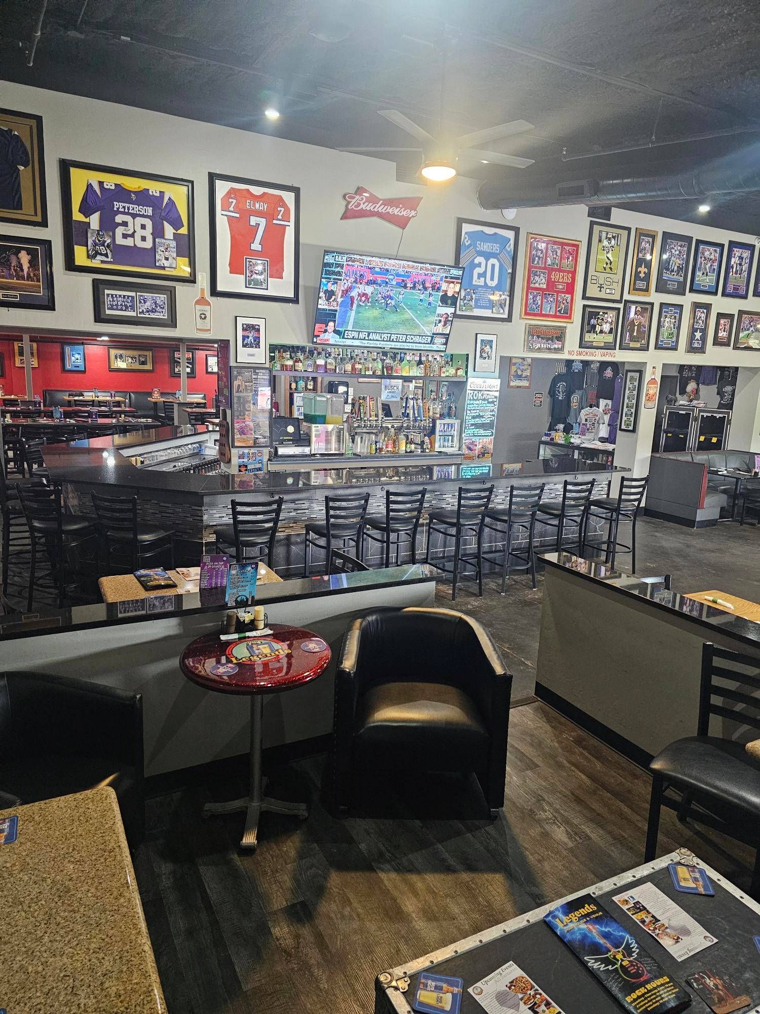 A restaurant with a lot of pictures on the wall and tables and chairs.