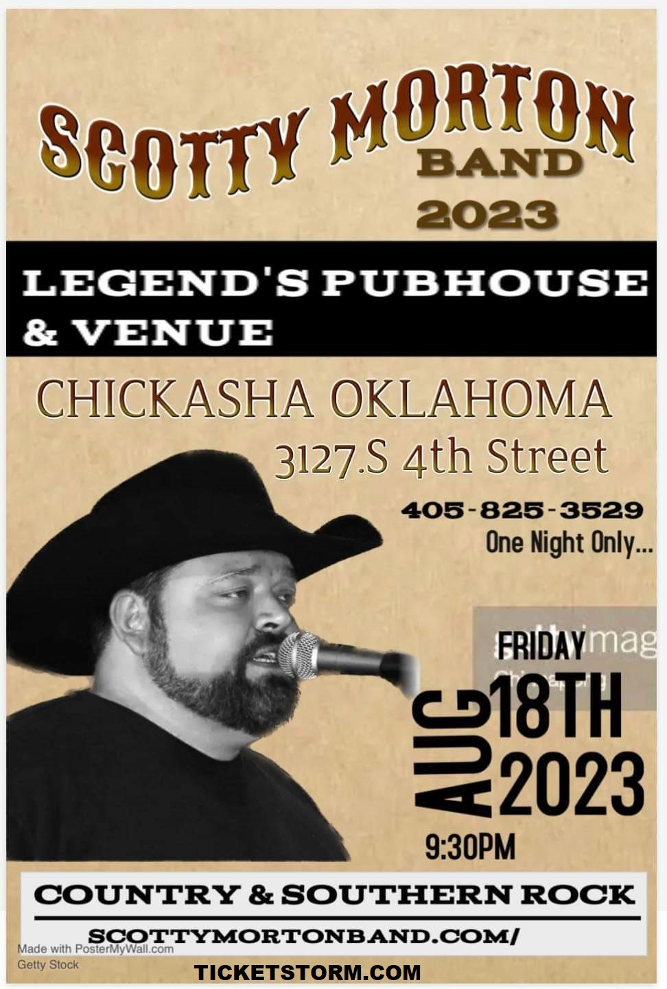 A man in a cowboy hat is singing into a microphone.