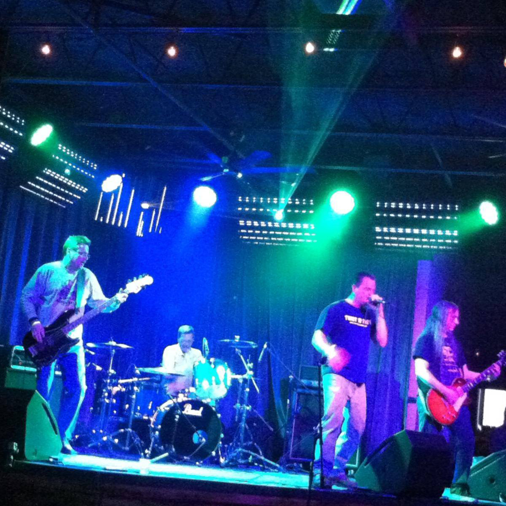A band playing instruments on a stage with a marshall drum in the foreground