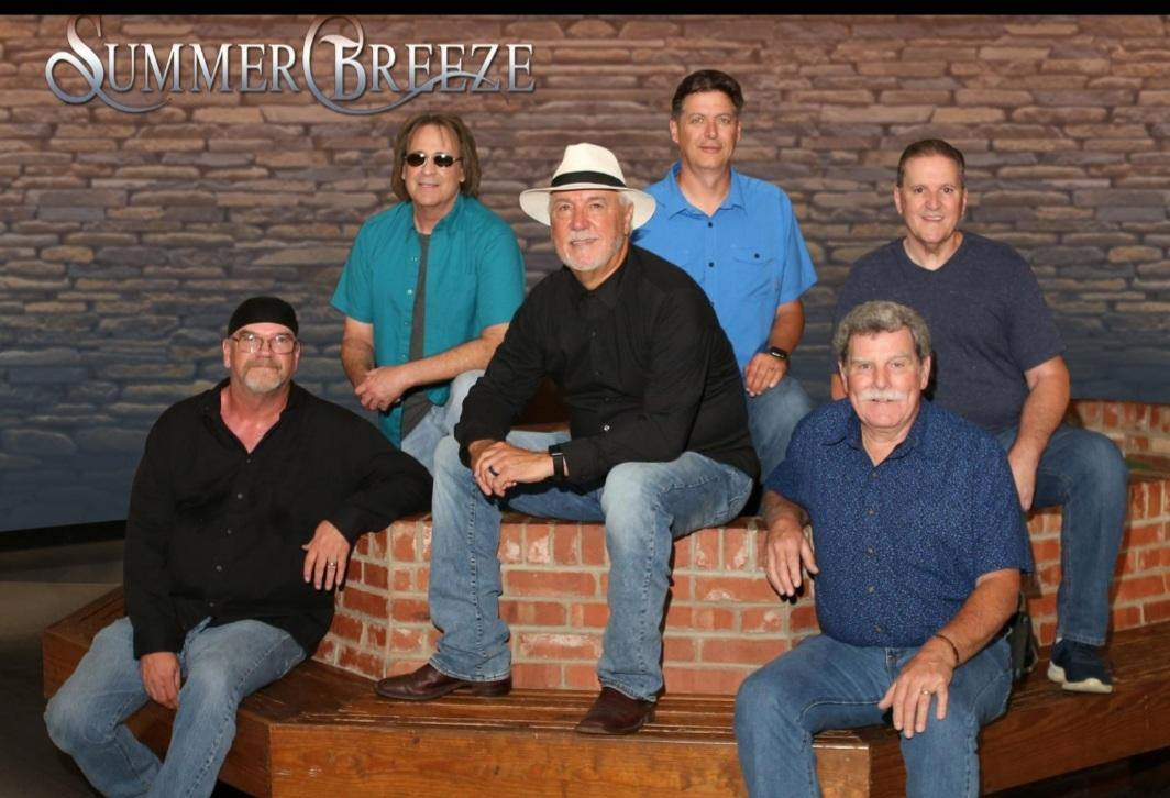 A group of men are posing for a picture with the name summer breeze on the bottom