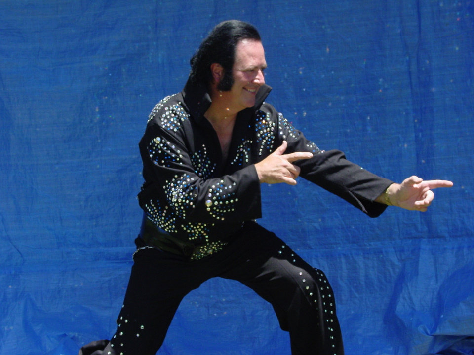 A man in a black jacket and pants is pointing at something
