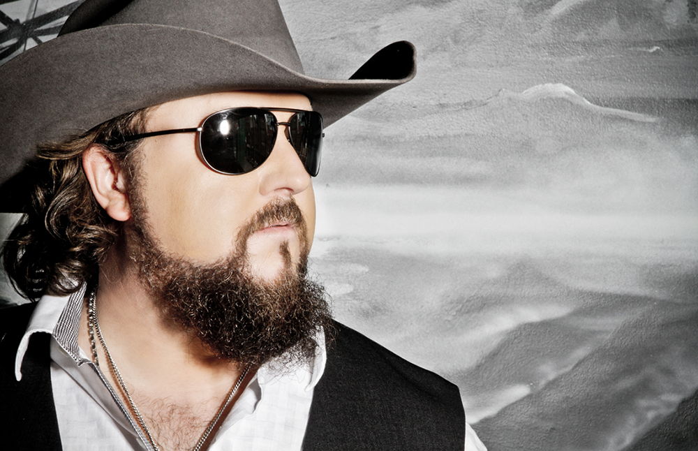 A man with a beard wearing a cowboy hat and sunglasses