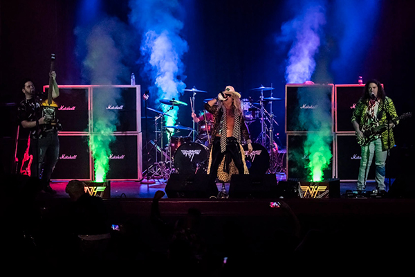 A group of people are standing on a stage with smoke coming out of them.