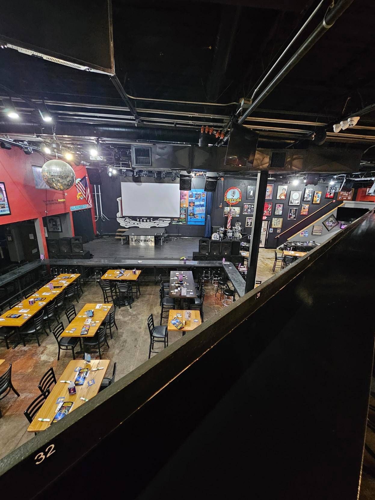 An aerial view of a restaurant with tables and chairs and a stage.