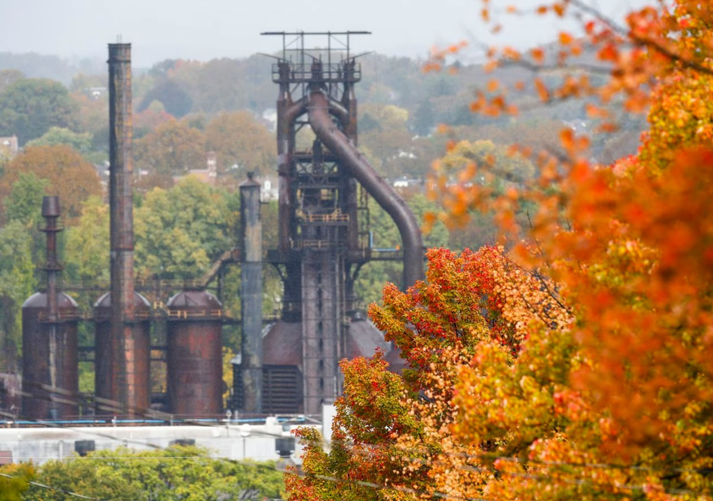 there is a factory in the background with trees in the foreground