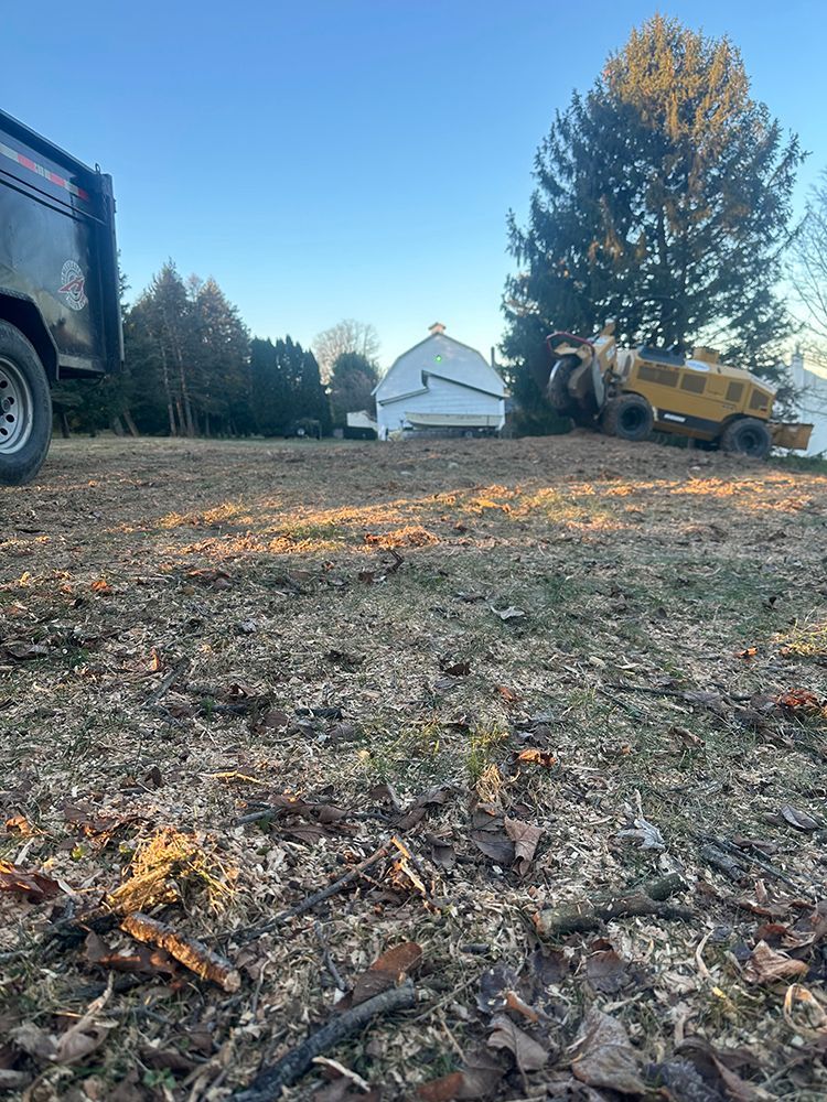 a truck is parked in a dirt field next to a barn
