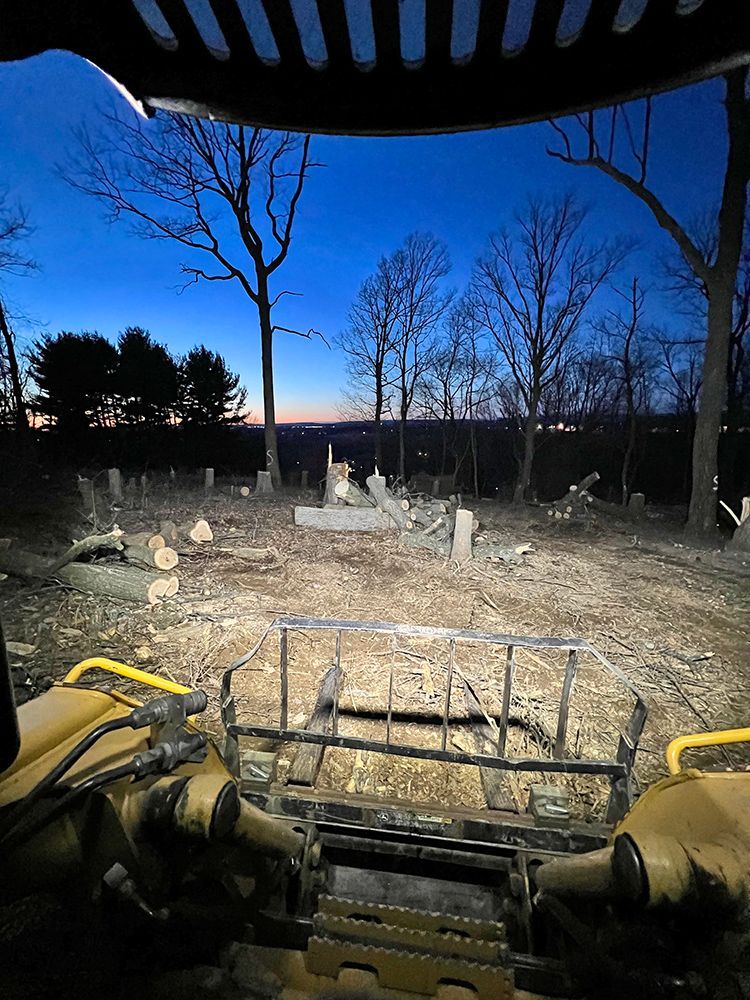 a bulldozer is driving through a dirt field at night