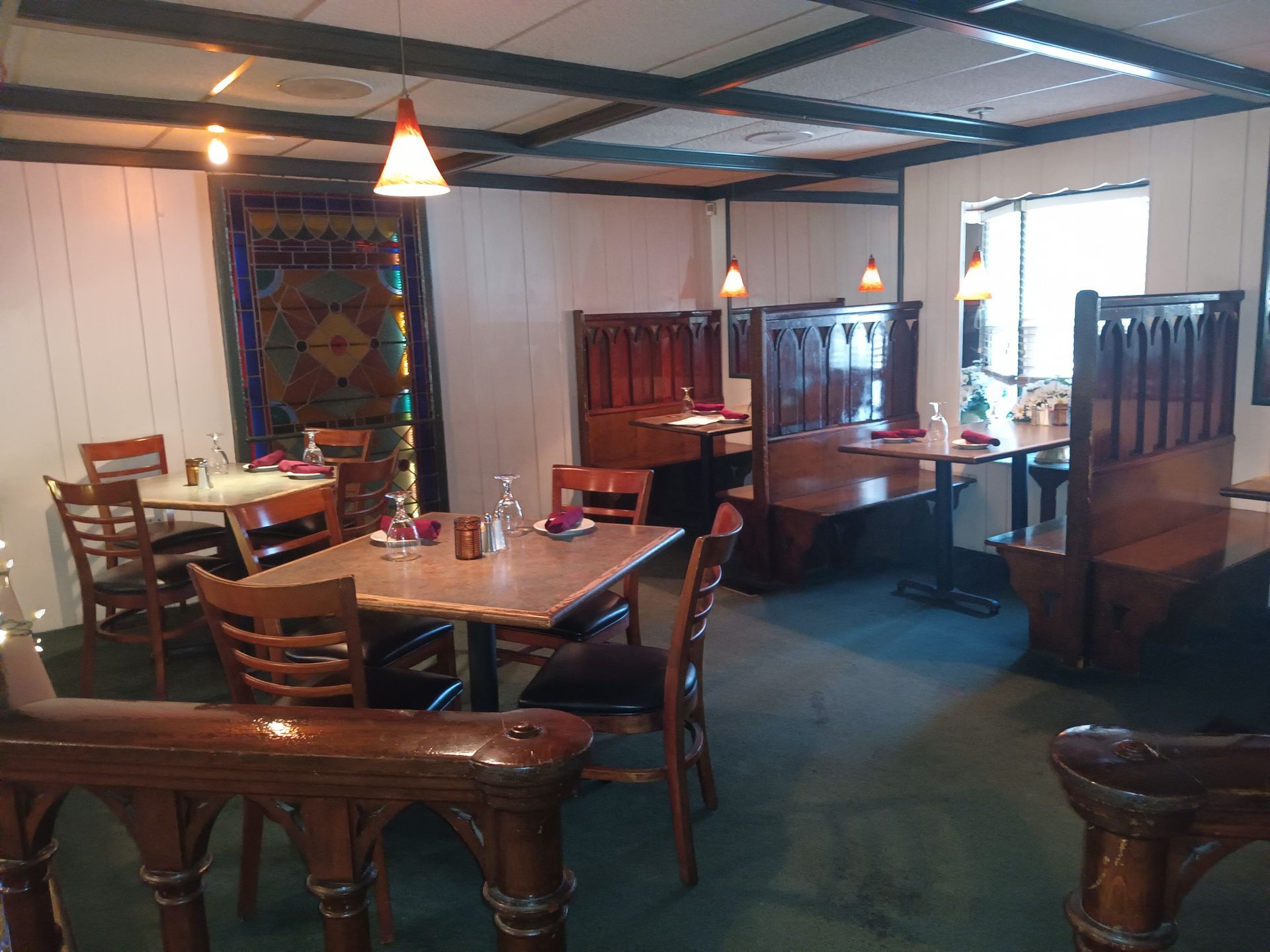 A restaurant with tables and chairs and a clock on the wall.