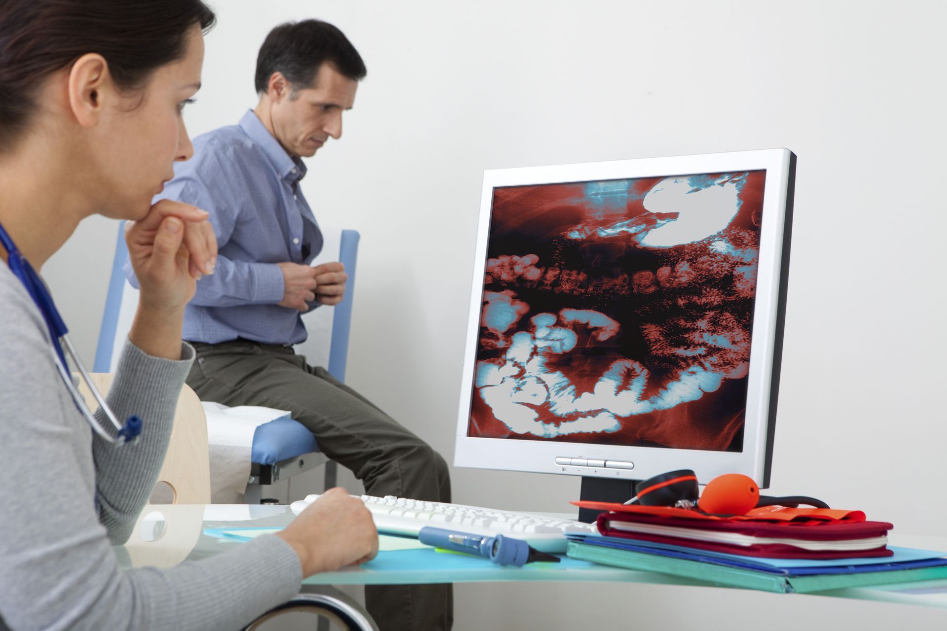 Doctor and patient looking at a medical image on a computer monitor in a doctor's office.