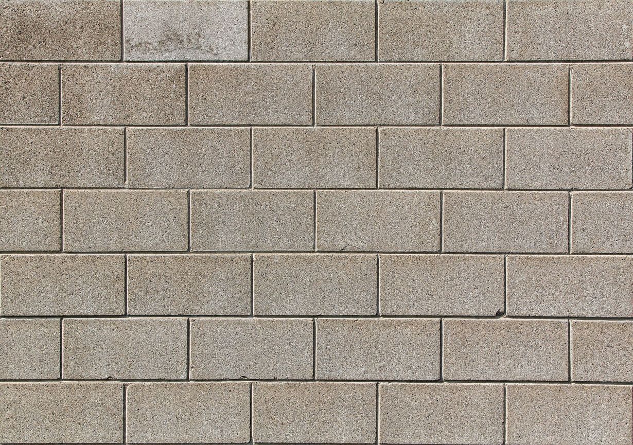 Close-up of a beige concrete block wall with horizontal mortar lines.