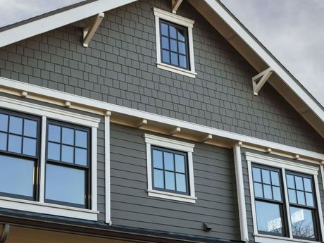 Gray house exterior with multiple black-framed windows and white trim