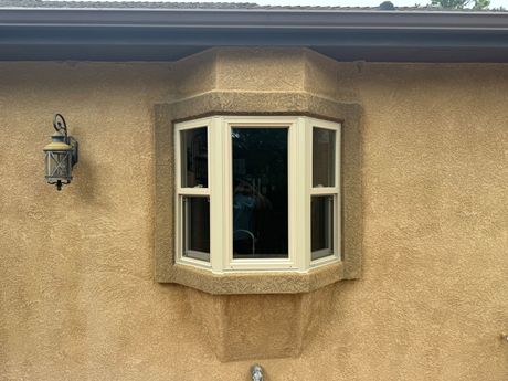 A bay window is on the side of a house.
