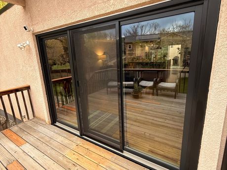 A sliding glass door leading to a deck in a house.