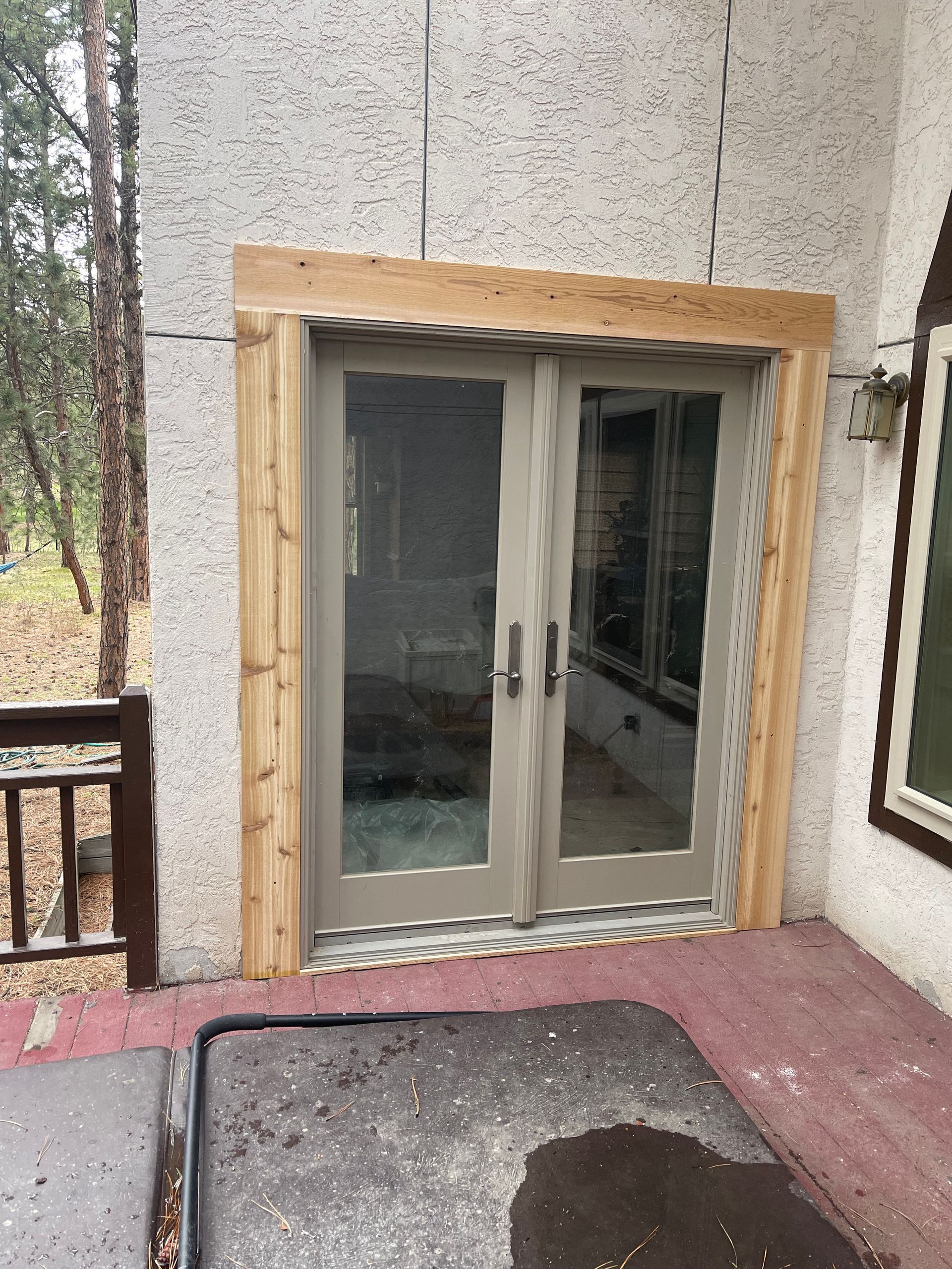 A sliding glass door is being installed on the side of a house.