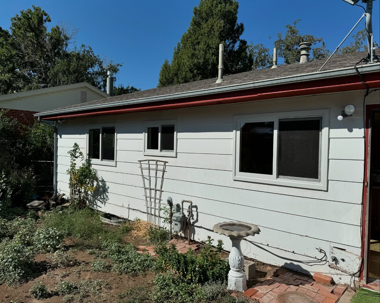 A white house with a bird bath in front of it