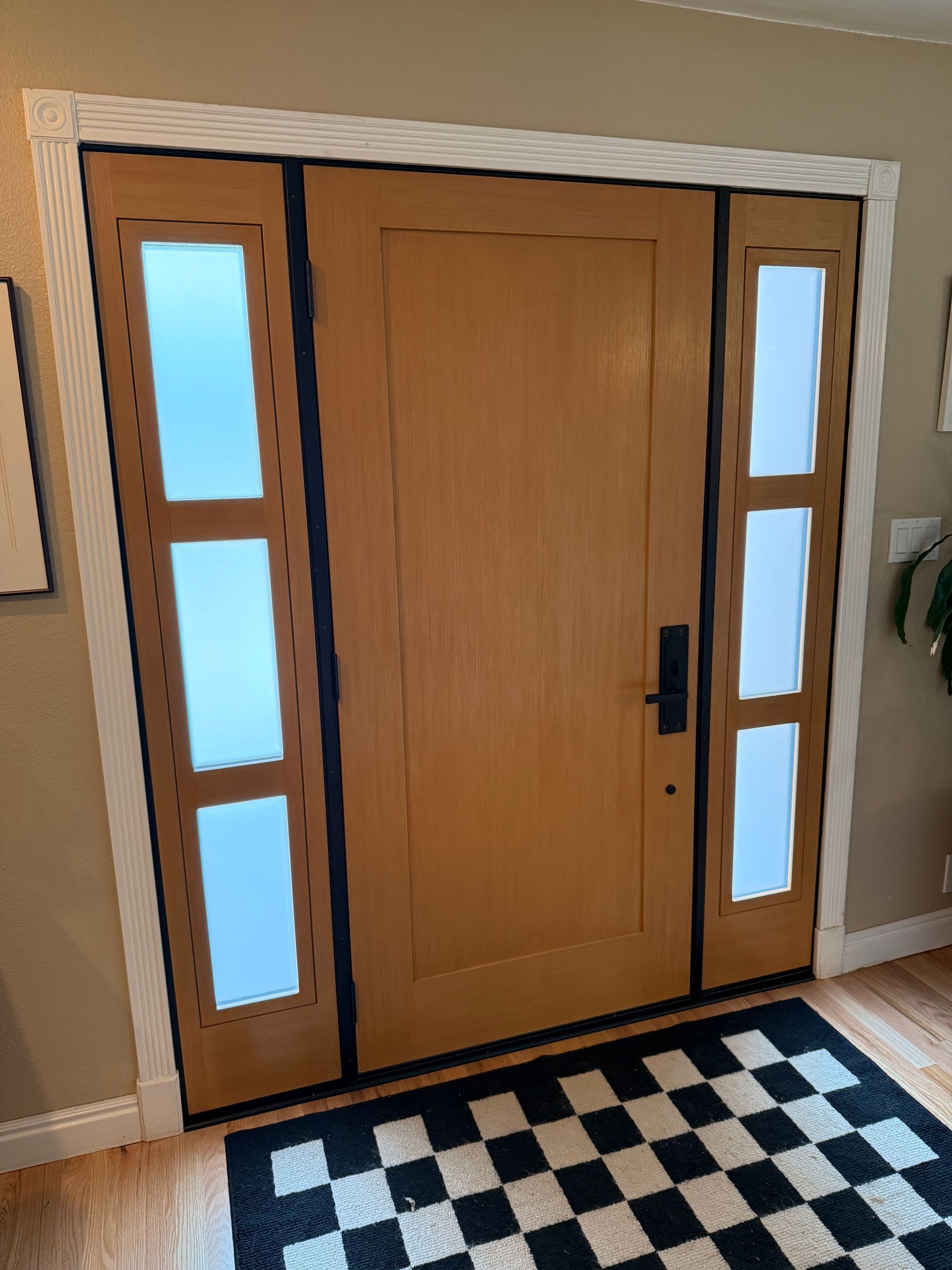A wooden door with a checkered rug in front of it