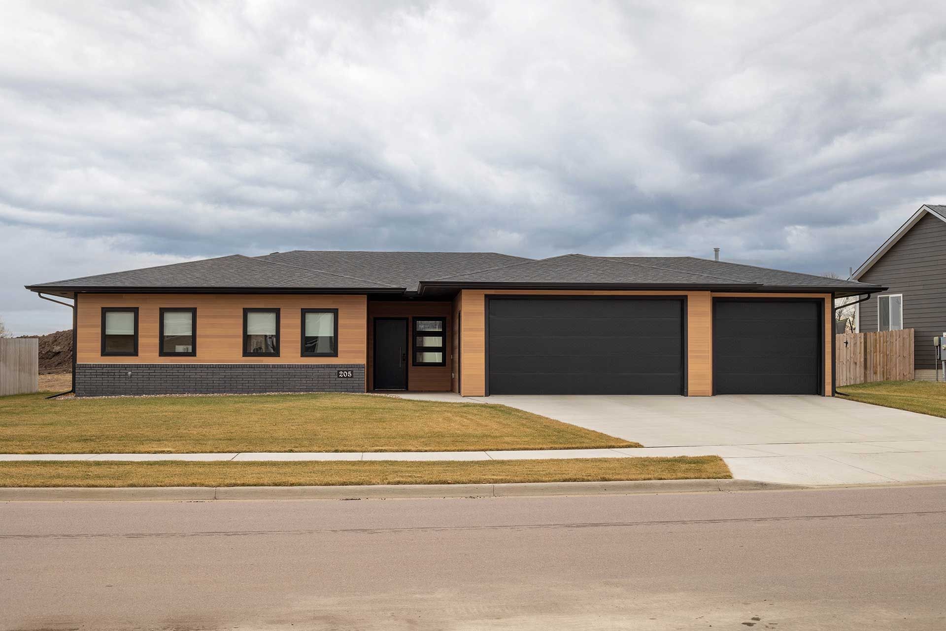 a bungalow with black garage doors