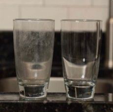 One glass with hard water spots and another with no stains