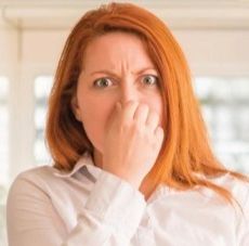 A woman covering nose due to  bad smell