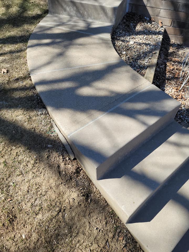 A concrete walkway with stairs leading up to a house