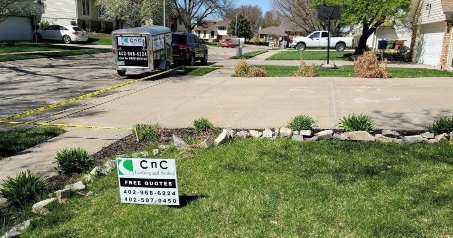 A CNC sign is sitting in the grass in front of a house