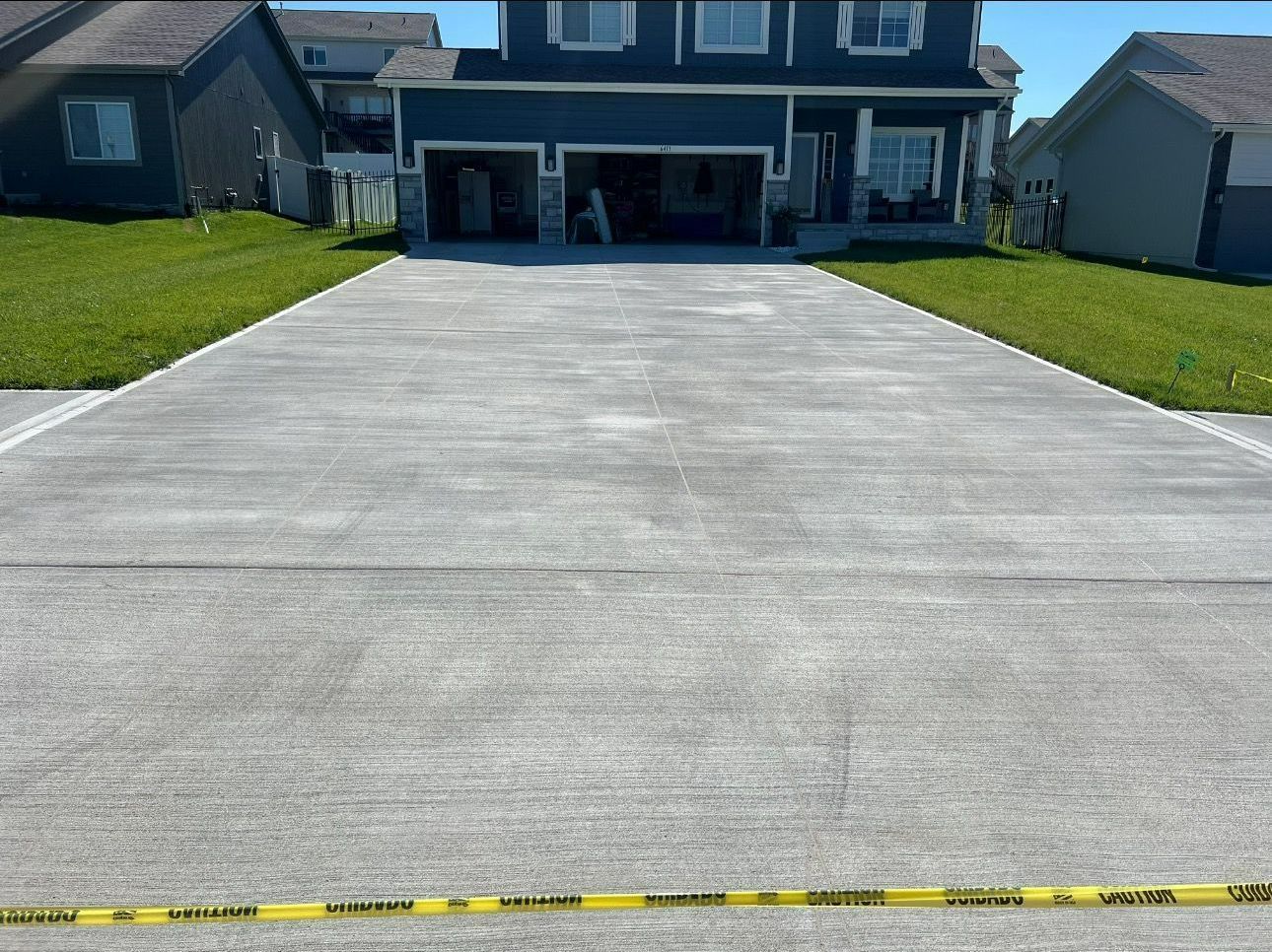 A concrete driveway leading to a large house