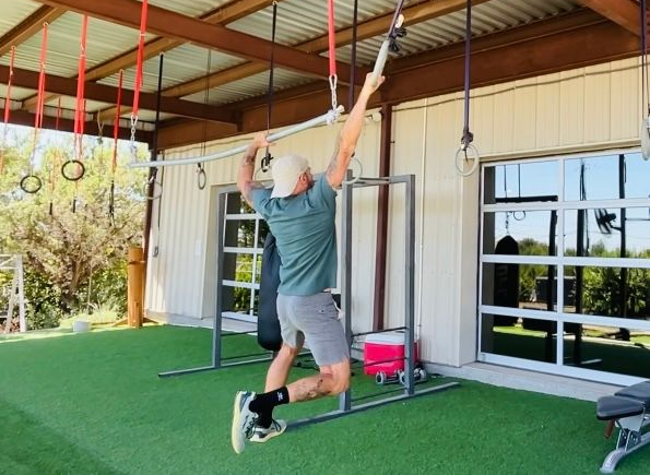A woman is pushing a sled with a metal plate in the background.