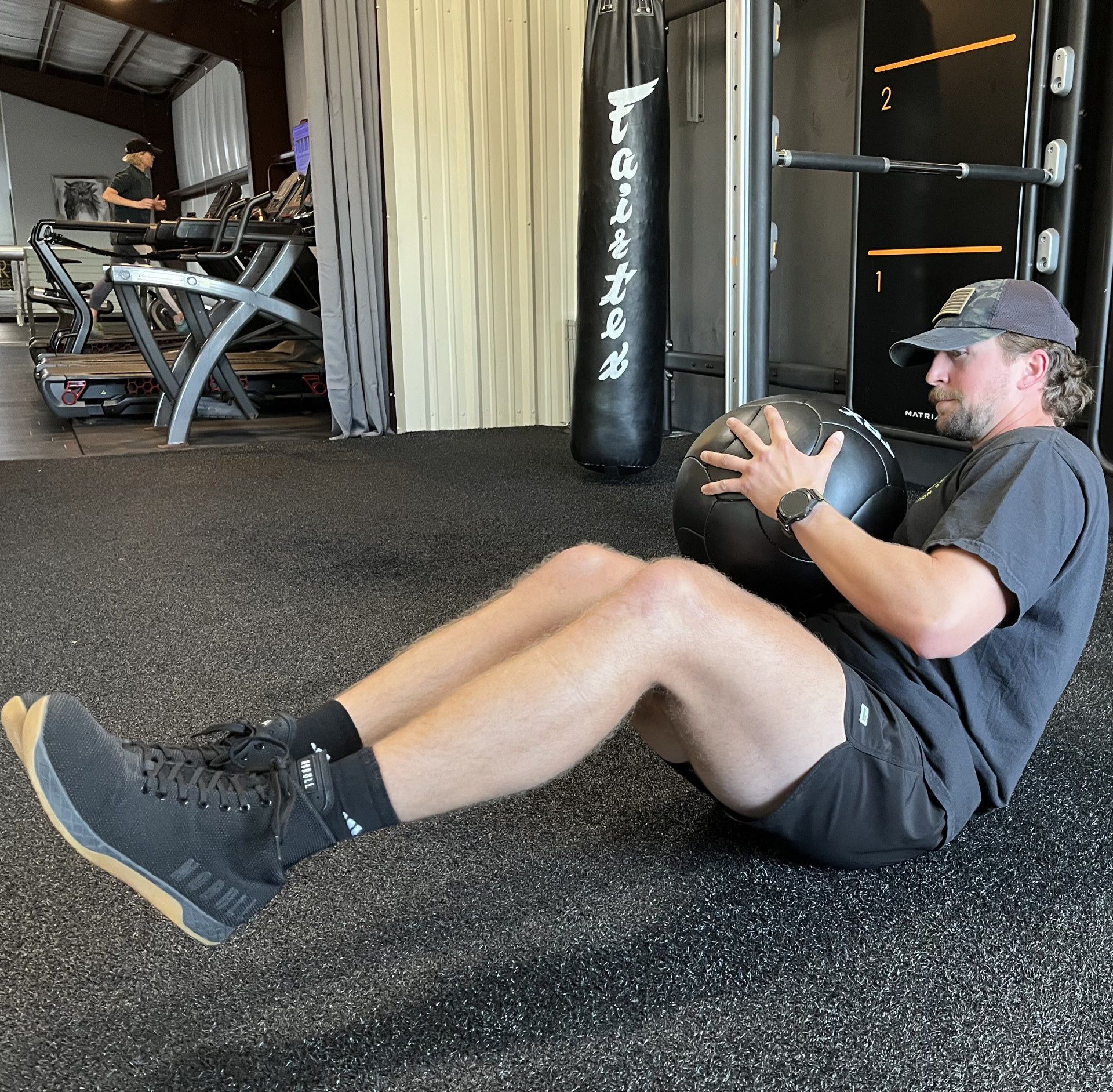 A man is doing sit ups with a medicine ball in a gym
