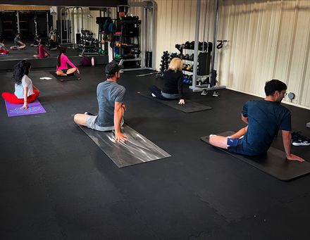 A man is doing a crunch with a medicine ball in a gym.