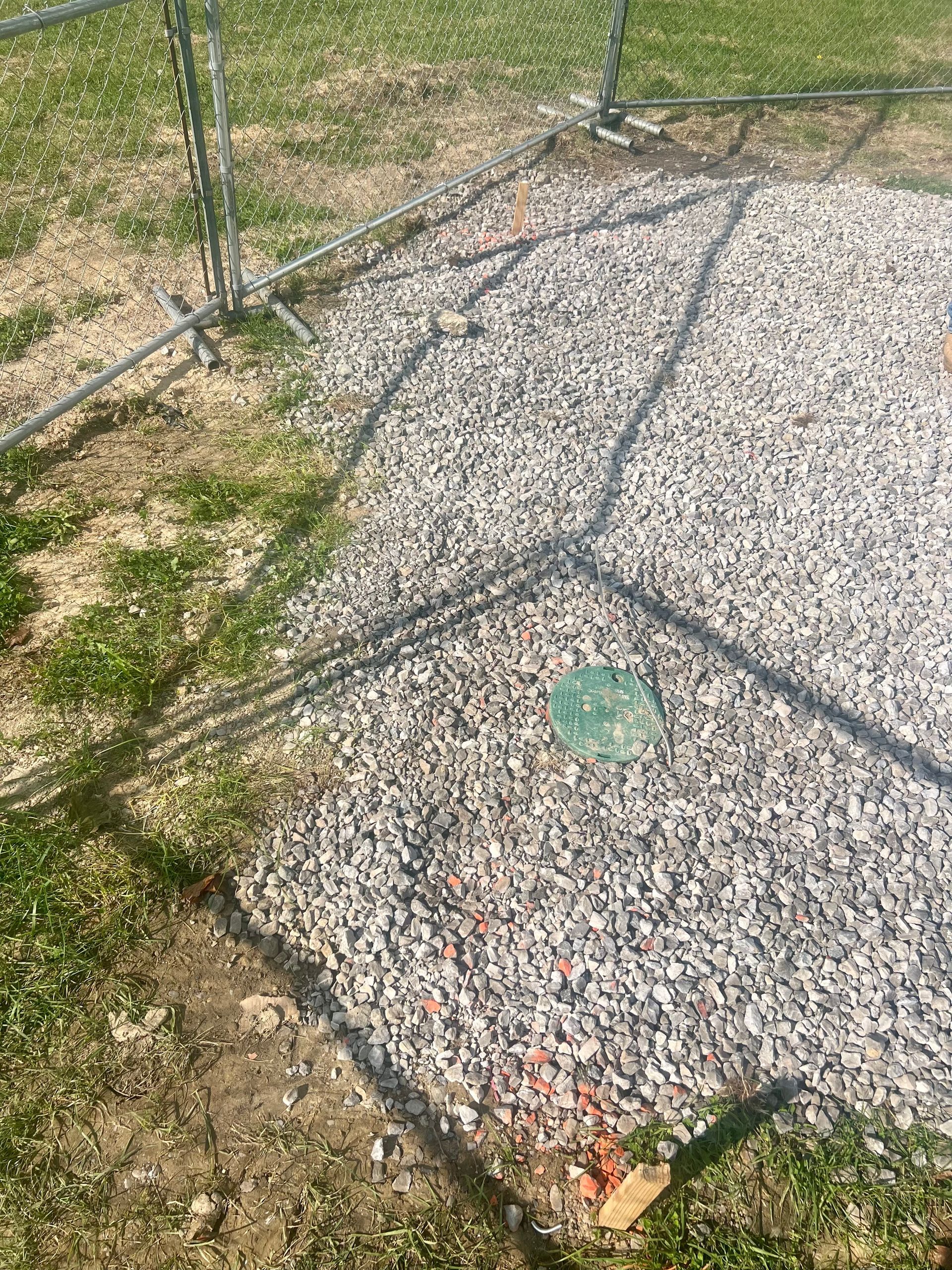 There is a green object in the middle of the gravel