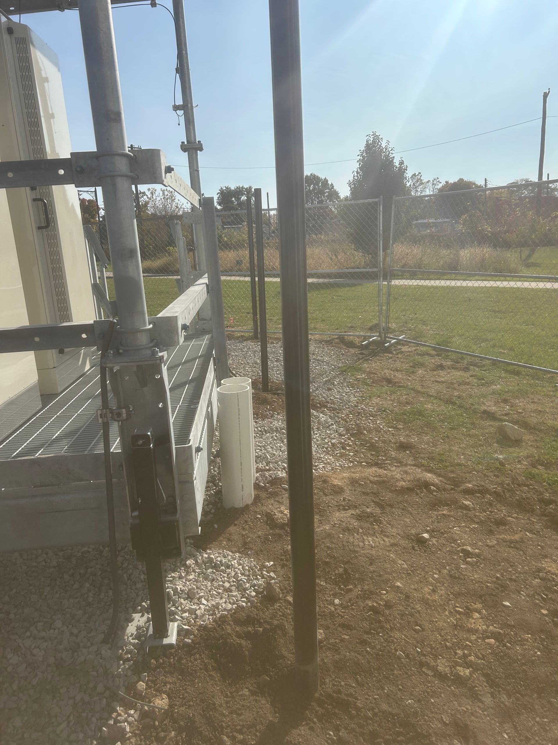 A fence is surrounding a building in a field
