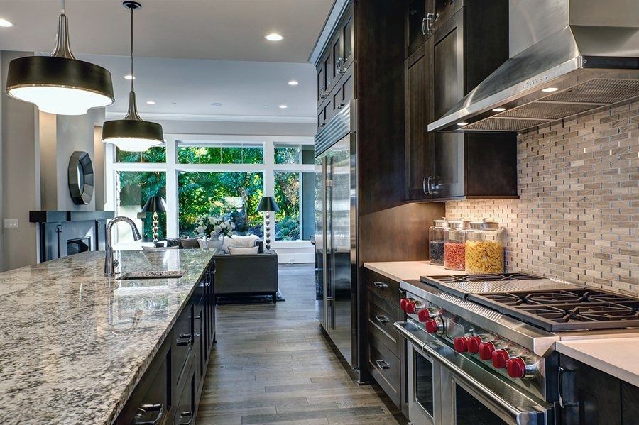 A kitchen with granite counter tops and stainless steel appliances.