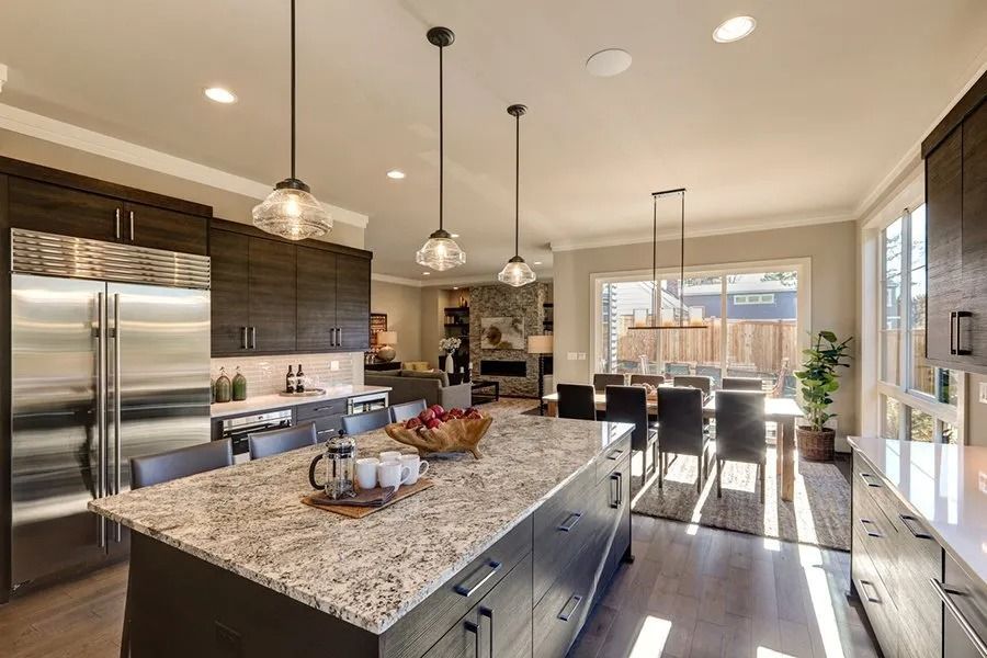 A kitchen with granite counter tops and stainless steel appliances.