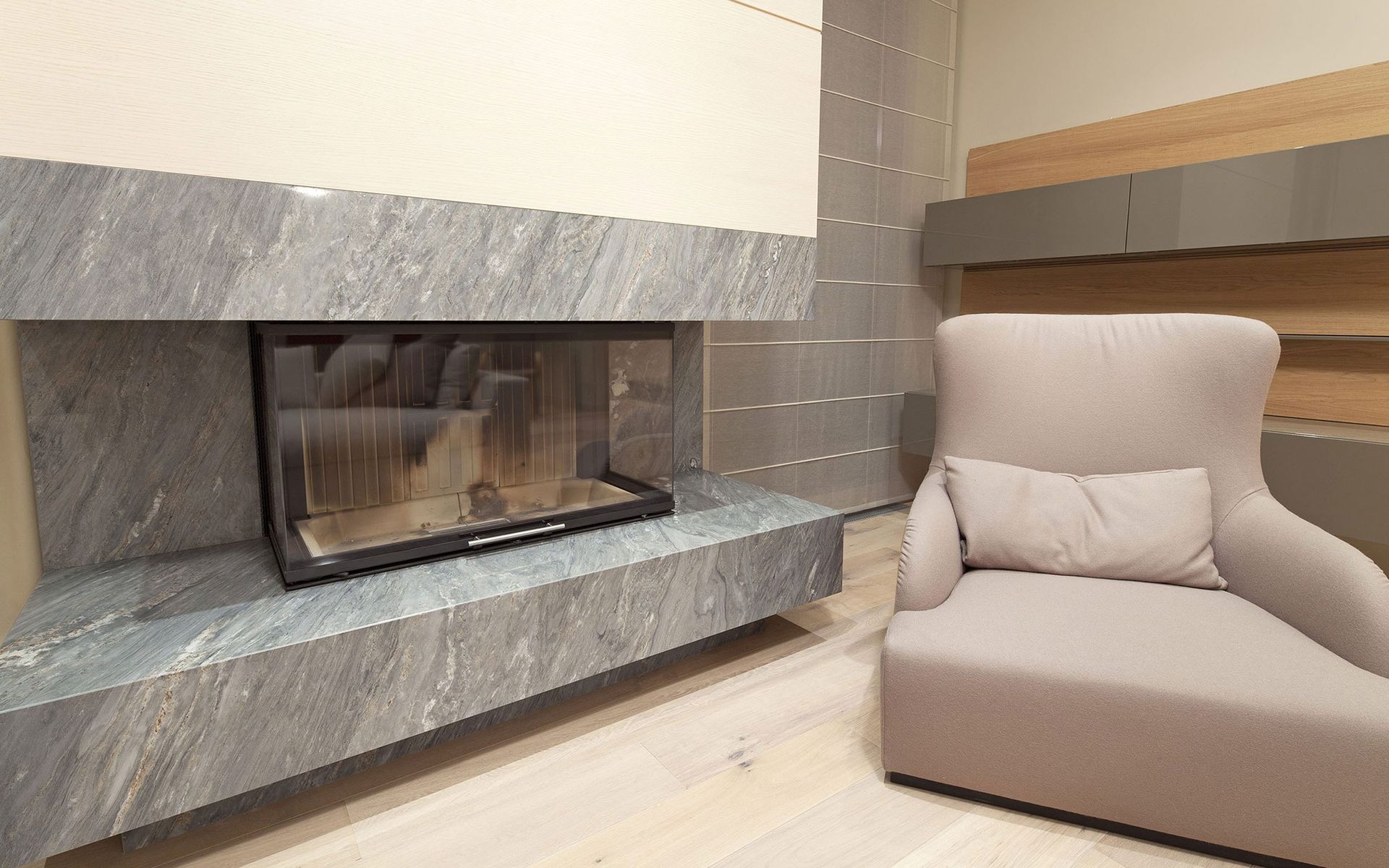 A living room with a fireplace and a chair.