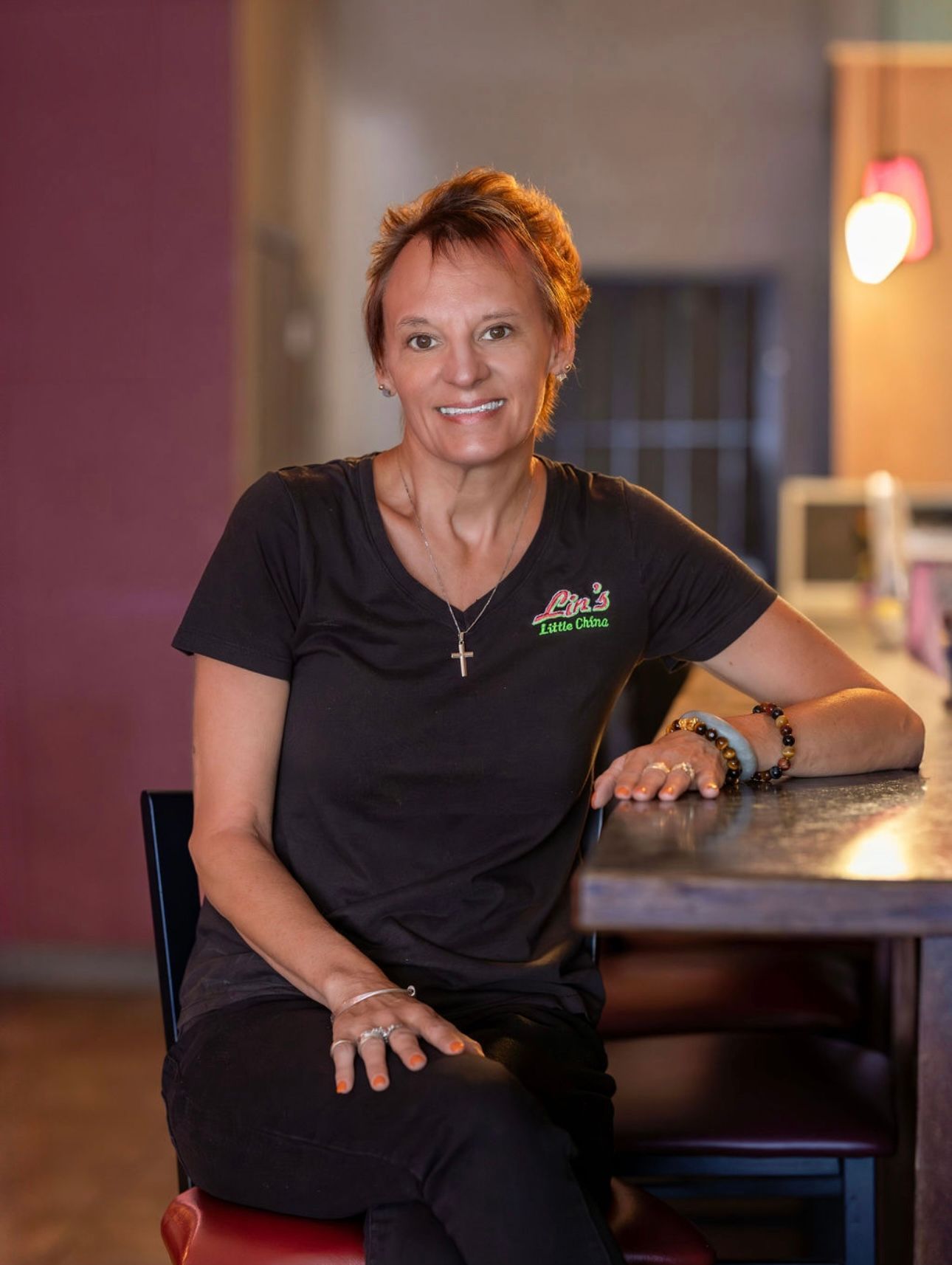 A woman in a black shirt is sitting at a table.