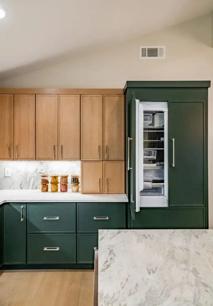 Green and wood-tone kitchen with a partially open refrigerator, and countertop with jars.