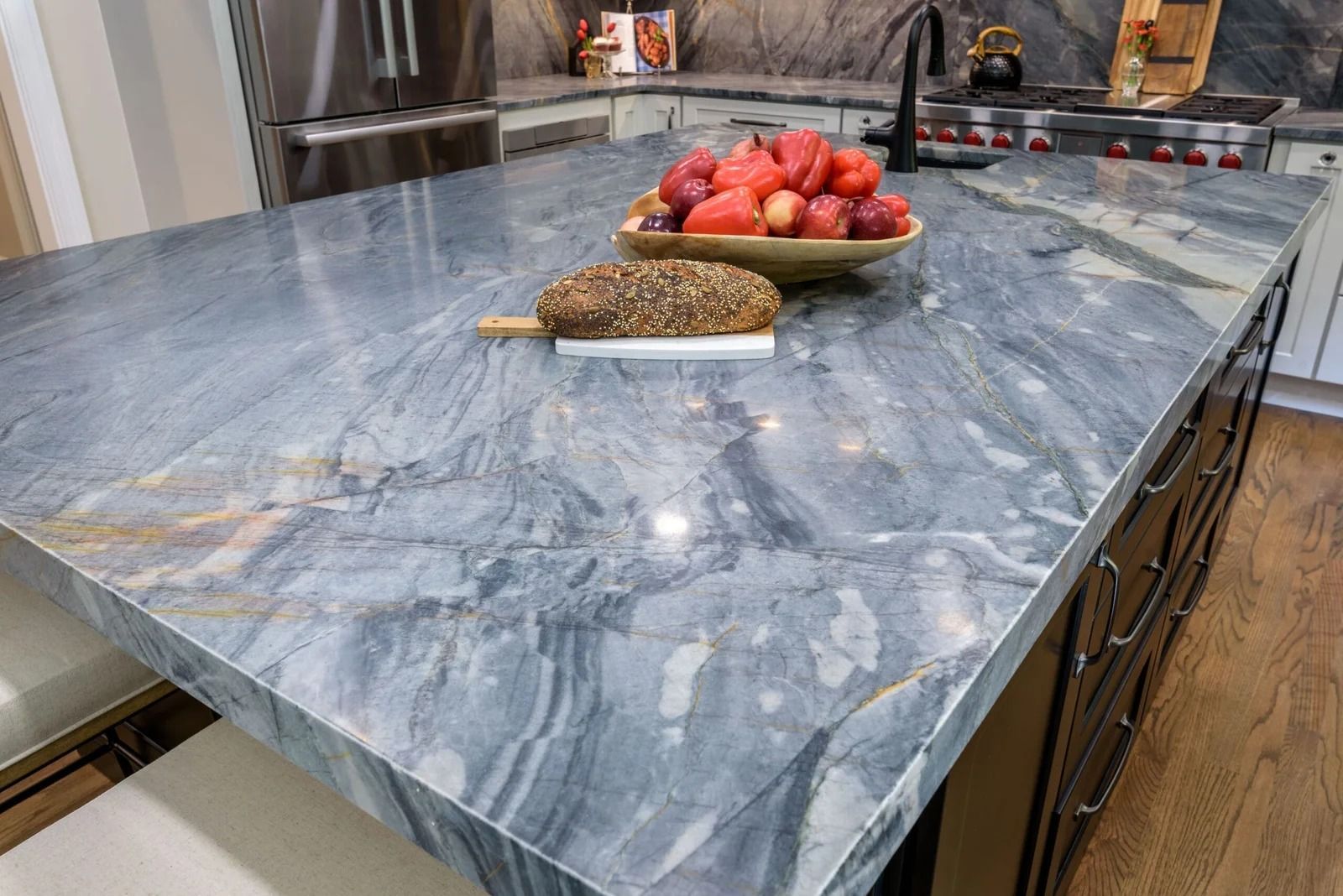 Blue marble kitchen countertop with fruit bowl and bread.