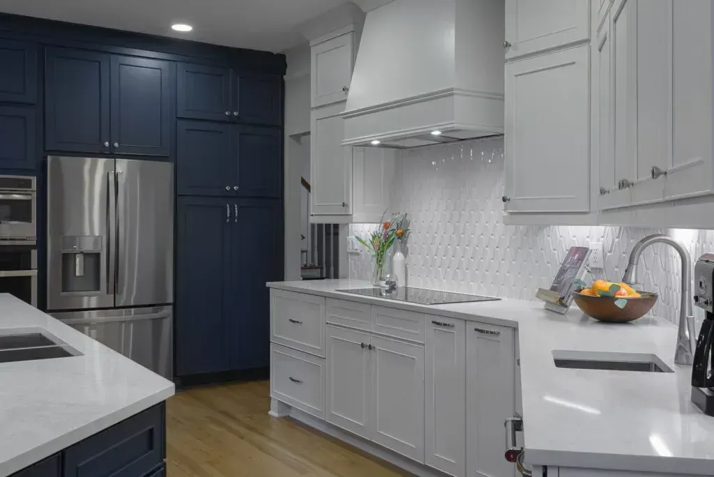 Kitchen with blue and white cabinets, stainless steel appliances, and white countertops.