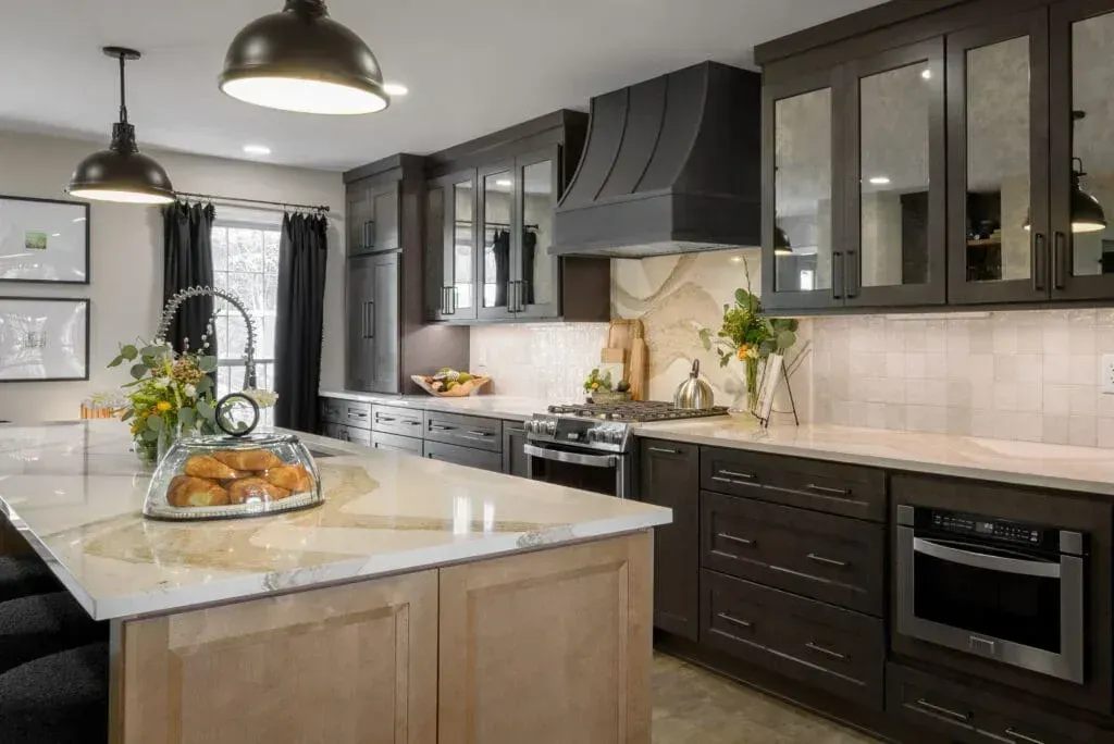 Modern kitchen with dark cabinetry, light countertops, and island with seating.