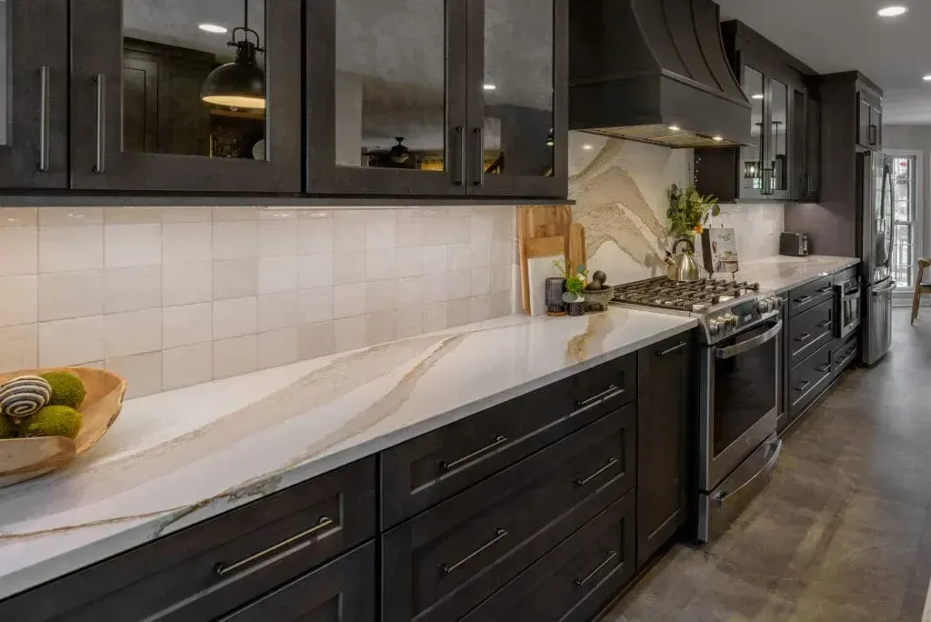 Dark wood kitchen with white countertops and backsplash.