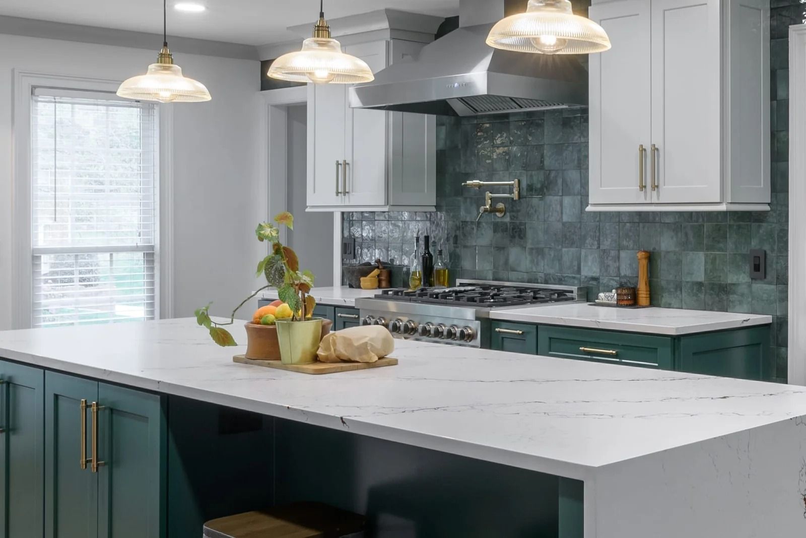 Modern kitchen with white countertops, green cabinets, and blue tile backsplash.