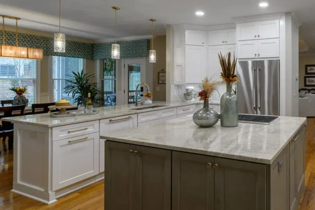 Spacious kitchen with a large island, white cabinets, and wooden floors.